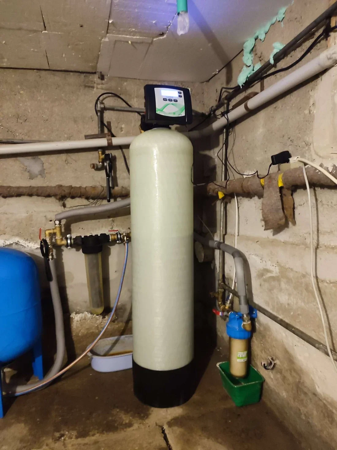 Kolóna s filtračnou náplňou, elektronickou riadiacou hlavicou a mechanickými predfiltrami v pivnici domu